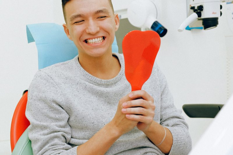 A man admires him gums after gum depigmentation procedure.