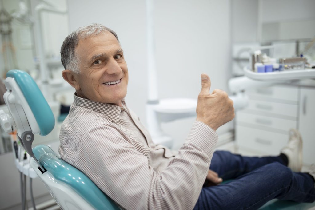 man gives thumbs up about no surgery treatment for gum disease